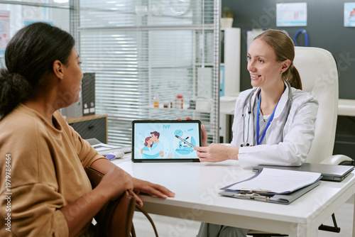 Cuadro en lienzo Female doctor showing IVF information on tablet while consulting Black woman in
