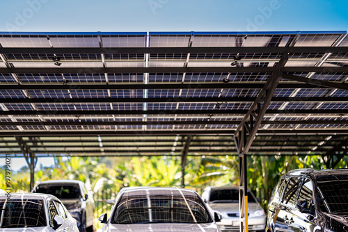 Fotografie Engineer in safety vest and helmet pointing towards a solar powered carport, illustrating eco-friendly innovation in parking infrastructure