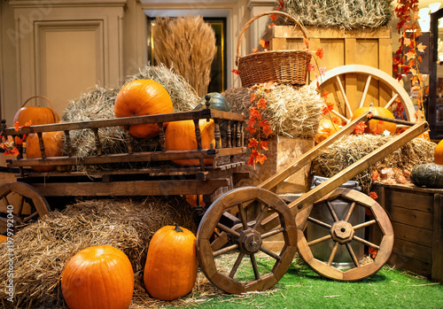 A beautiful composition on the theme of Halloween: pumpkins, rustic carts, bales of straw.