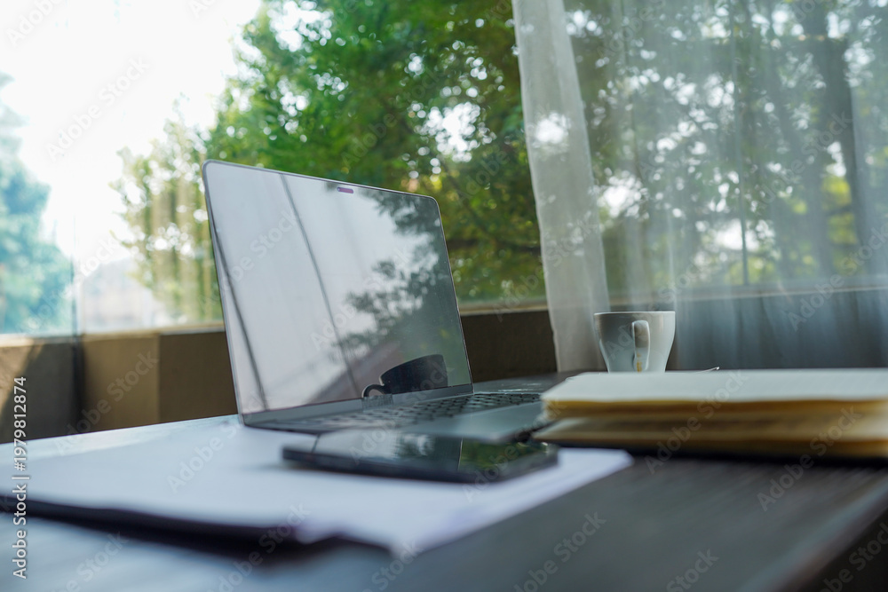 Fototapeta premium Flat lay of professional desk with business charts on laptop screen, smartphone and notepad.