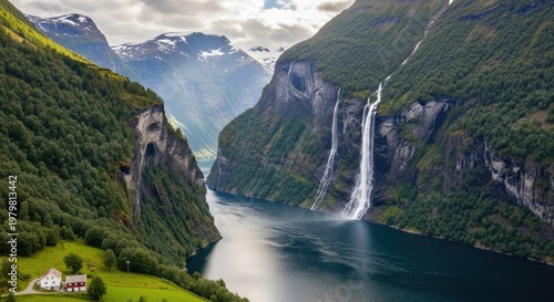 A breathtaking view of a fjord with a waterfall cascading down the side of a mountain, surrounded by lush greenery and towering cliffs.