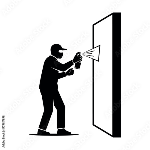 Silhouette of a person spray painting a wall.