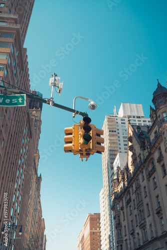 Traffic light signal in the city. American style yellow traffic light in New York City. Traffic in the city. Background with classical buildings.