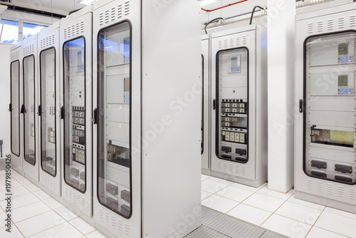 A clean and organized electric room features rows of specialized control panels and protection relay cabinets in an electrical substation.