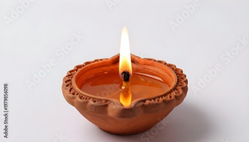 Single clay diya with a bright flame burning, symbolizing light and tradition