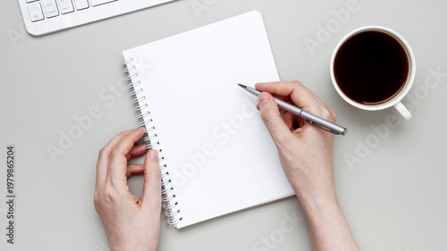 Photos Woman jotting notes in notebook with coffee enhancing focus and productive work