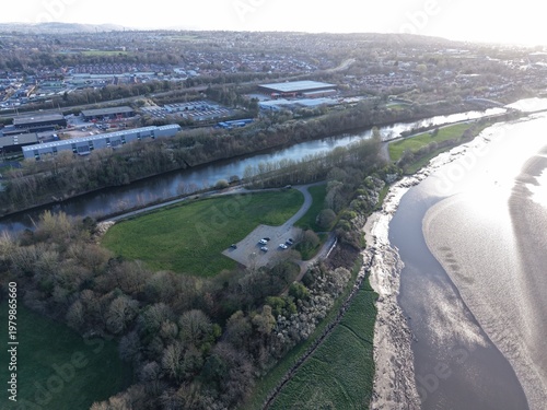 Photos River Mersey Aerial View of Sunlit Riverbank and Natural Grassland Zone
