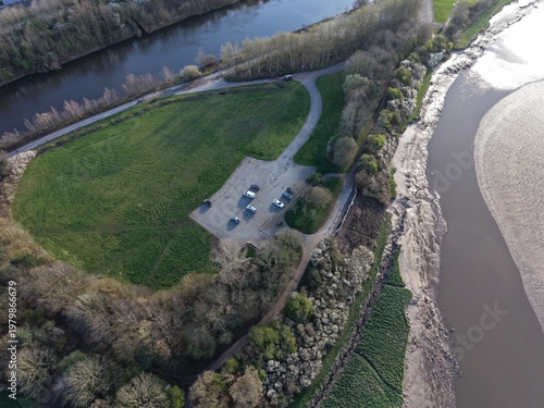 Photos River Mersey Aerial View of Estuary Water and Sunlit Open Grassland