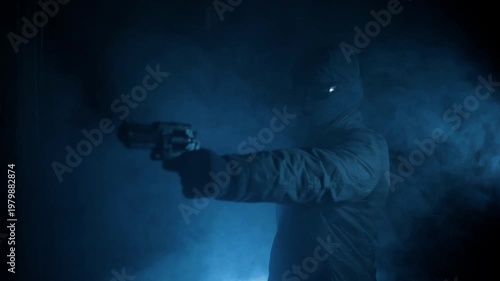Anonymous Hooded Man Aiming and Firing Gun in Dark Smoke, Crime Threat Concept
