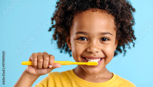 Niño cepillándose los dientes con cepillo dental en fondo azul claro, concepto de higiene bucal infantil, salud dental, hábitos saludables en la infancia y educación e higiene