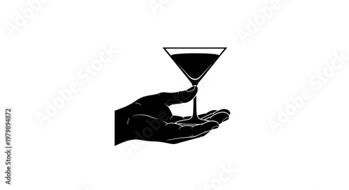 A hand holding a martini glass with a dark liquid inside