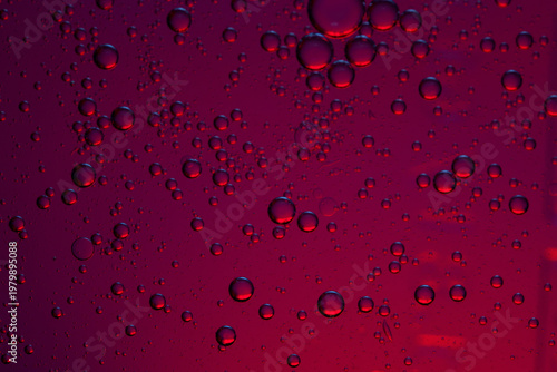 Fotografie Bubbles in a dark red liquid, possibly a beverage or a chemical solution, creating an abstract pattern