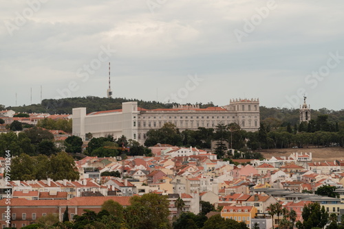 National Palace of Ajuda rising above red rooftops and trees in Lisbon Portugal