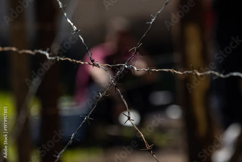 Close-up of a barbed wire against a blurred dark background. Selective focus, texture.