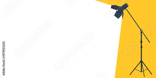 Studio spotlight on a stand illuminating a blank white area on a yellow background, copy space