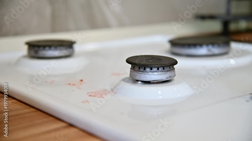 Close-up view of gas stove burners with visible grates and white surface