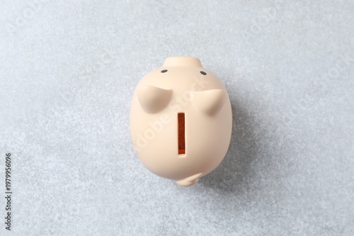 Piggy coin bank on grey table, for money savings, financial security or personal funds concept. Top view