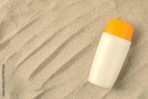Sunscreen lotion on sand against isolated background