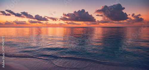 Captivating panoramic tropical ocean waves sunset dramatic sky vibrant purple orange golden clouds reflected calm water serene seascape nature travel background breathtaking coastal evening scenery