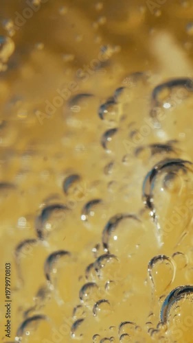 Slow Motion Extreme Close-Up Carbonation Bubbles Rising Through Lemon Mineral Water in Glass — Effervescence Hydration and Natural Sparkling Drink Concept Vertical