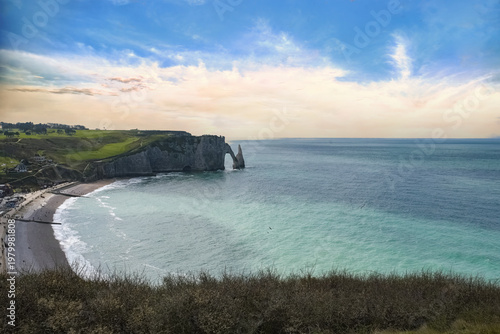 Etretat in Normandy, the famous cliffs and needle on the pebble beach
