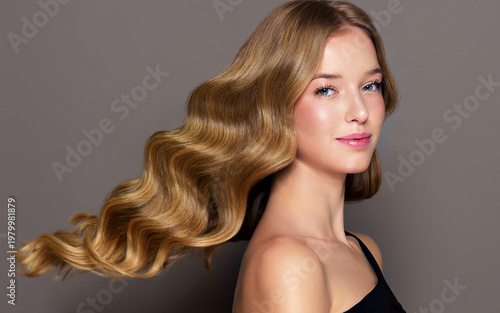 Beauty blonde girl with long and shiny wavy Hair ,coloring and toning, shatush , air touch and balayash . Beautiful woman model with curly hairstyle . Beauty salon and barbershop . Hair curling 
