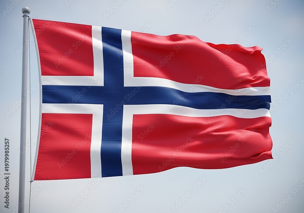 Fototapeta premium The vibrant red Norwegian flag with a blue cross bordered by white waving majestically on a flagpole under a clear sky