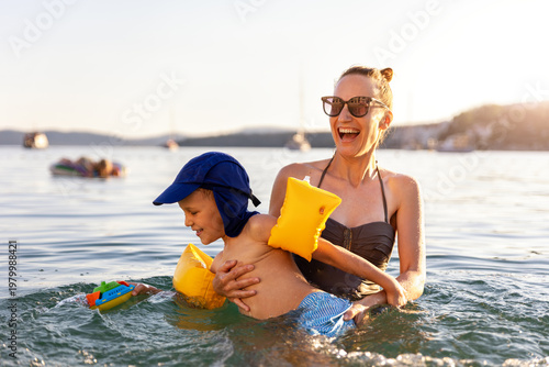 Photos Mother laughing have fun hold child sea swim warm summer sunset
