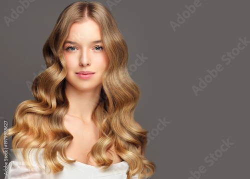 Beauty blonde girl with long and shiny wavy Hair ,coloring and toning, shatush , air touch and balayash . Beautiful woman model with curly hairstyle . Beauty salon and barbershop . Hair curling 
