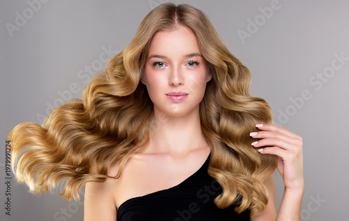 Beauty blonde girl with long and shiny wavy Hair ,coloring and toning, shatush , air touch and balayash . Beautiful woman model with curly hairstyle . Beauty salon and barbershop . Hair curling 

