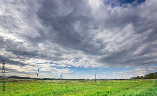 Fotografie Open field stretches under a vast, brooding sky