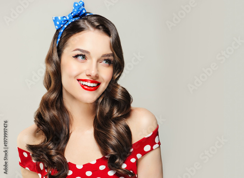 A Pin Up smiling young woman in a retro outfit  showcasing an invisible Presenting your product .Beautiful smile vintage girl with curly hair  .Expressive facial expressions. wavy hairstyle