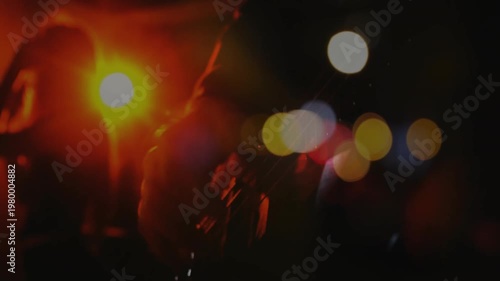 Guitarist silhouette playing electric guitar on dim stage featuring flat design red orange lights