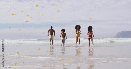 Bild auf Leinwand Running family of four splashing in shallow surf on wet sand, wearing swimwear w