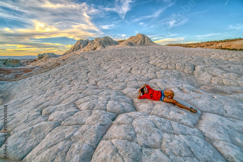 Bilde på lerret A woman is laying on a rock in a desert