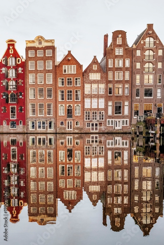 Reflection of Famous Dutch Damrak Dancing Houses in Amsterdam Canal Water, Iconic Urban Architecture