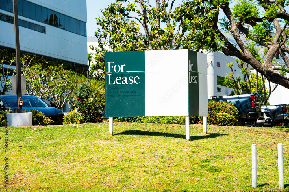Obraz premium Commercial property for lease sign in front of modern office building