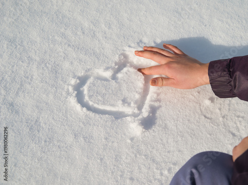 The romantic gesture of drawing a heart in the snow