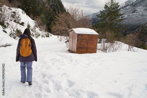 A girl hiking along a snow-covered trail in a mountainous landscape. In the Pyrenees in Spain.