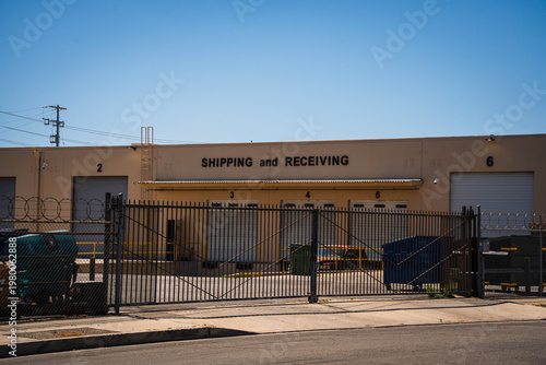 Commercial warehouse with shipping and receiving bays under a clear blue sky