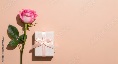 Pink rose bouquet with wrapped gift box on soft pink background for Mother's Day celebration
