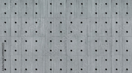 Geometric Precision: A close-up view reveals a meticulously crafted concrete wall, its surface adorned with an intricate pattern of evenly spaced holes.