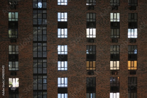 a brick wall of a skyscraper at night with glowing windows