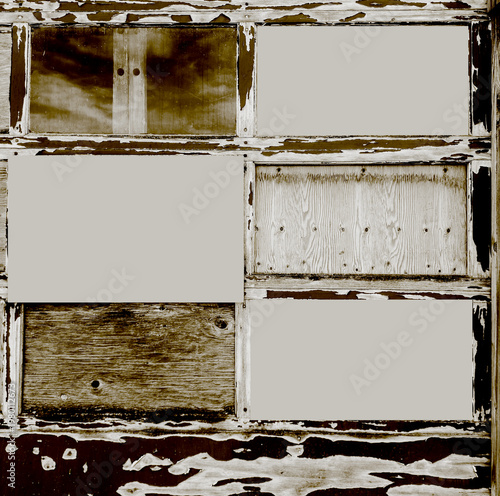 Text spaces on image of old boarded up garage door gets attention. Paint is peeling, Wood is old & patched. Junk building exterior looks like it is falling apart.