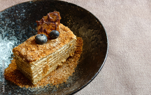 Εκτύπωση καμβά A delicious slice of layered honey cake, known as medovik, topped with fresh blueberries a crunchy caramel shard