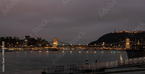 View from Buda Embankment of famous Szechenyi Chain Bridge illuminated by floodlights in Budapest in Hungary