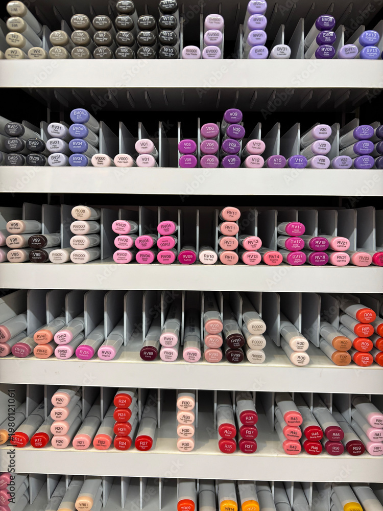 Fototapeta premium Organized colorful markers in storage rack, art supplies background, creative studio color palette