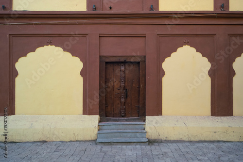 Decorative stone carved Arches, Windows & Wooden Door of fort wall of Rajwada, Indore, Madhya Pradesh. Also known as the Holkar Palace or Old Palace. Indian Architecture.