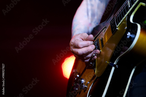 Close up of a musician playing an electric hollow body guitar during a live concert performance