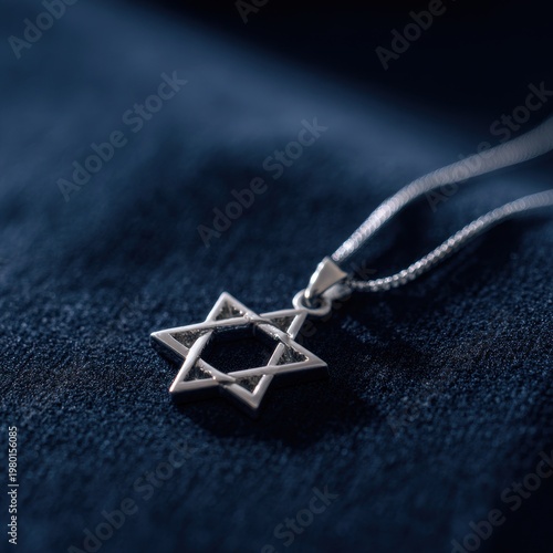 Close-up photograph of a silver Star of David pendant on a dark velvet surface with warm lighting
